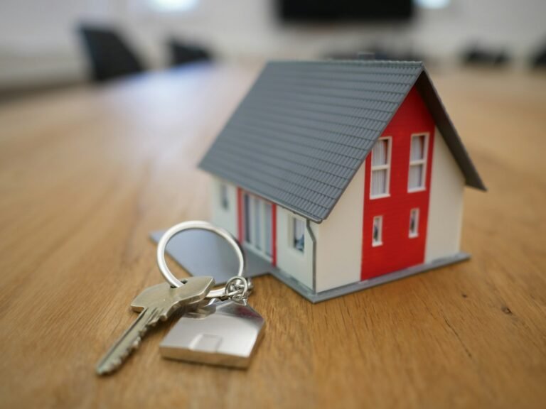 House model and keys on a desk, representing property placed in a living trust